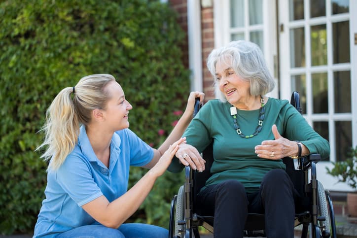 Immobilien im Gesundheitswesen, Pflegerin im Gespräch mit einer älteren Frau