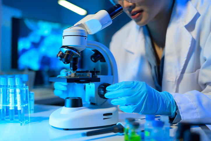 closeup of a scientist looking in a microscope, life science commercial real estate